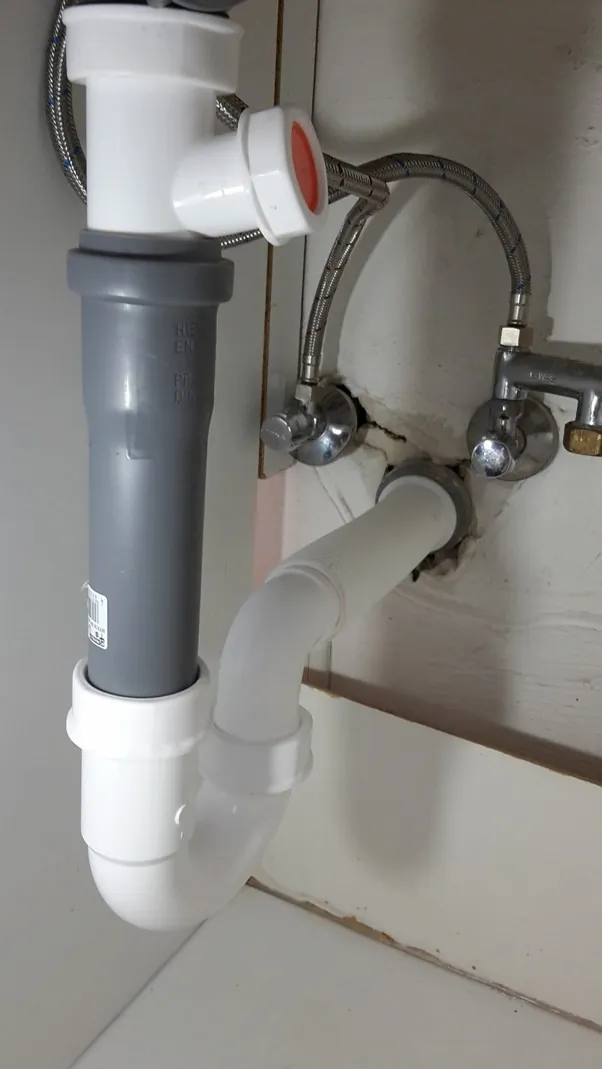 Siphon und Abflussrohr unter dem Waschbecken mit Wasseranschluss