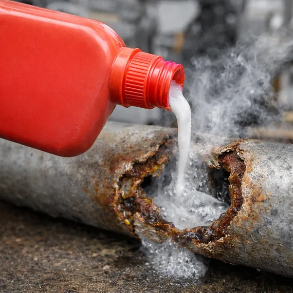 Chemischer Rohrreiniger wird in ein korrodiertes Abflussrohr gegossen